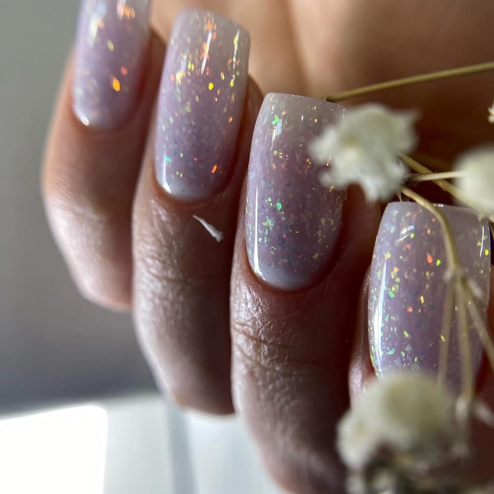 Sheer lilac nails with holographic flakes