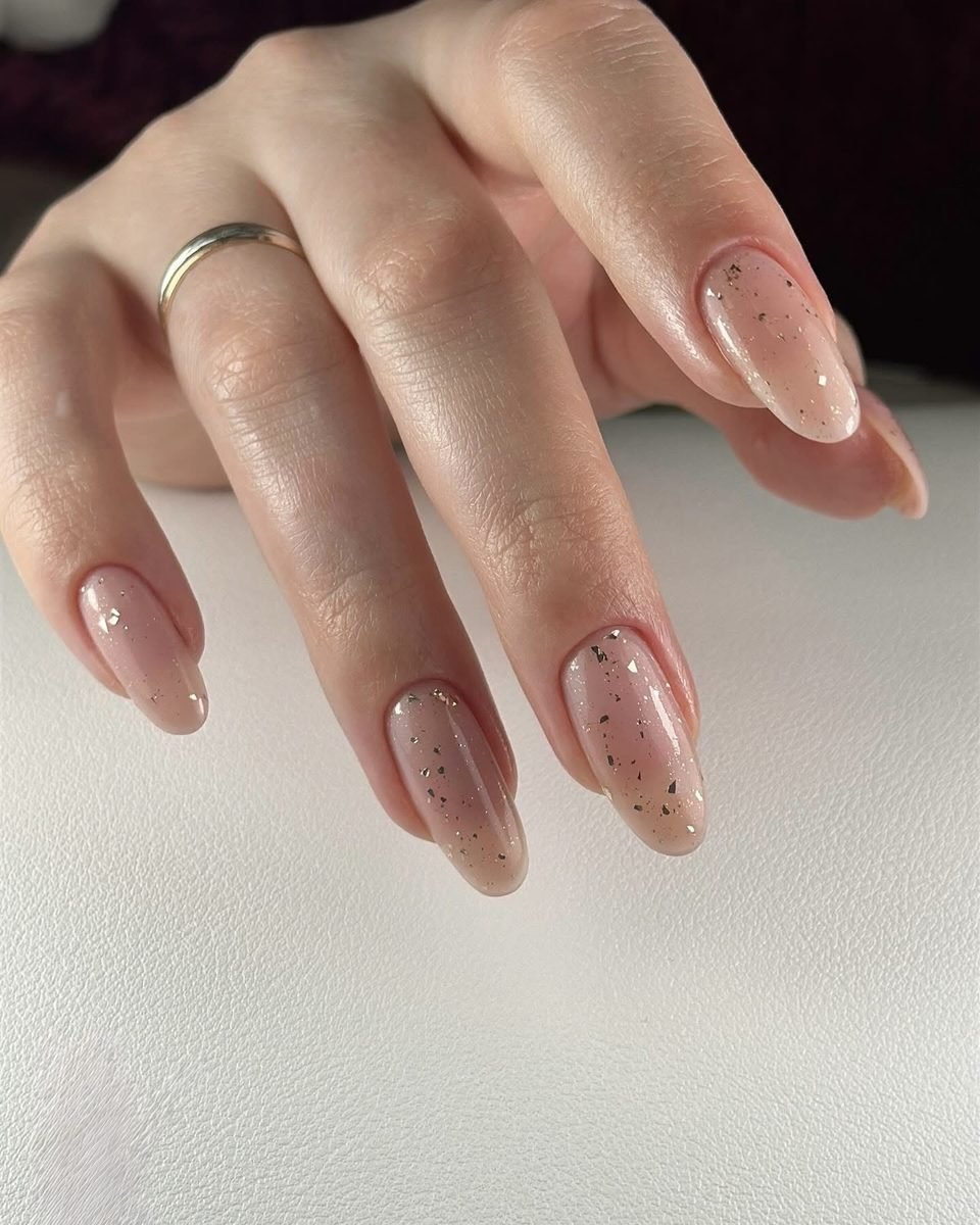 Long nude almond nails with tiny gold specks